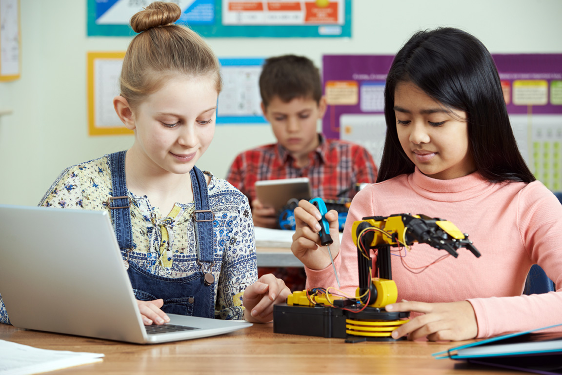 stock image of pupils studying robots in science class